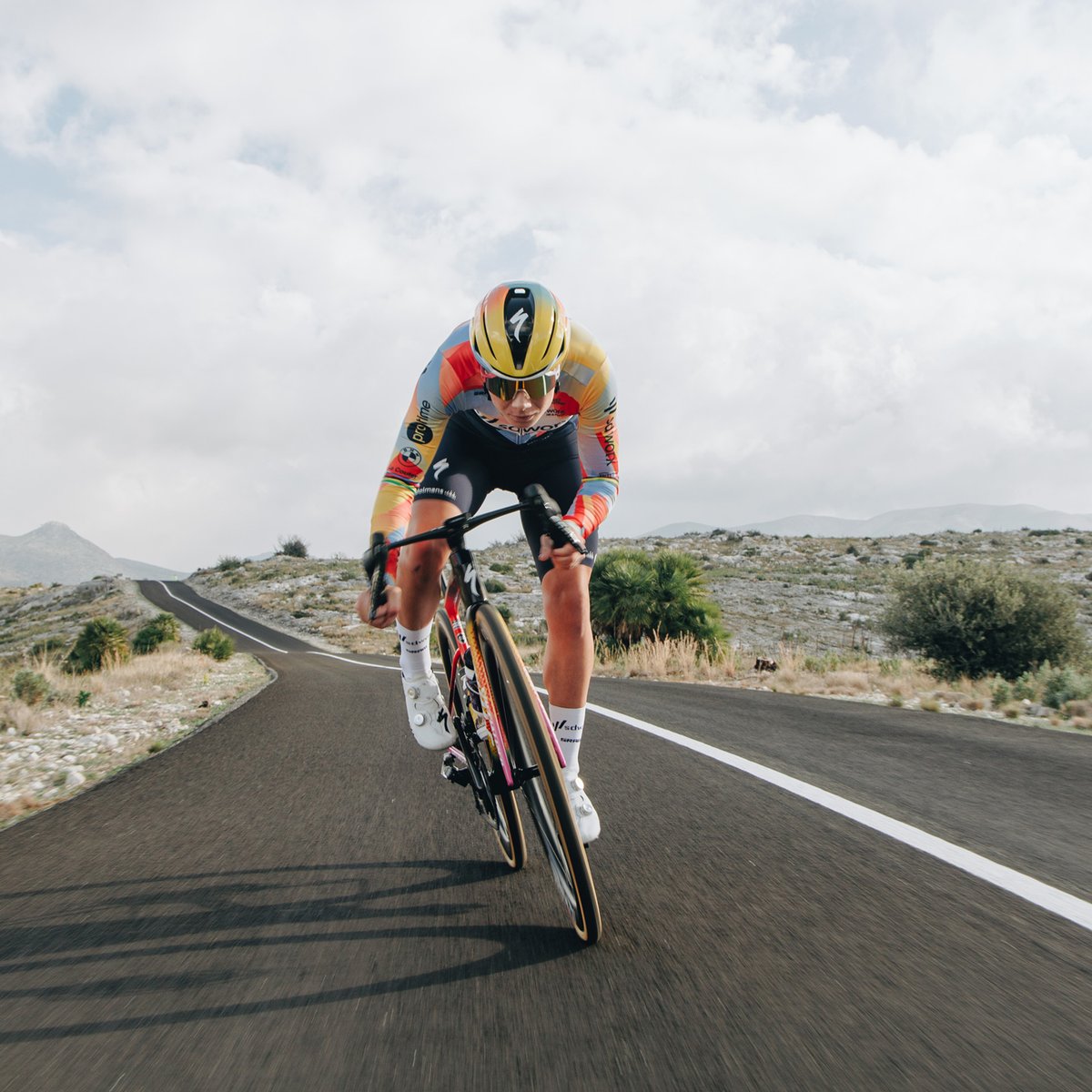 A person rides a bike down a road, wearing the Evade 4. 