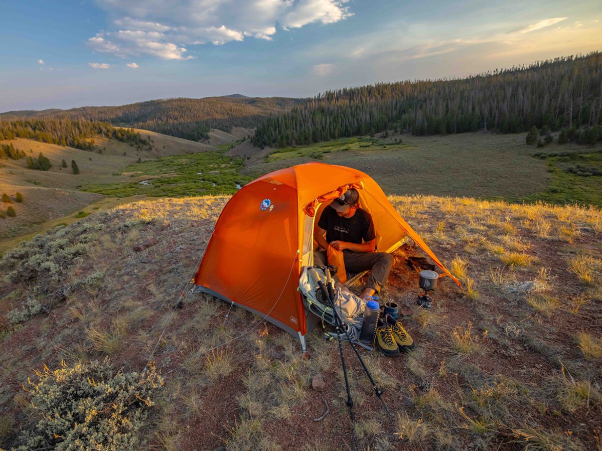 A person sits in the door of their Copper Spur tent