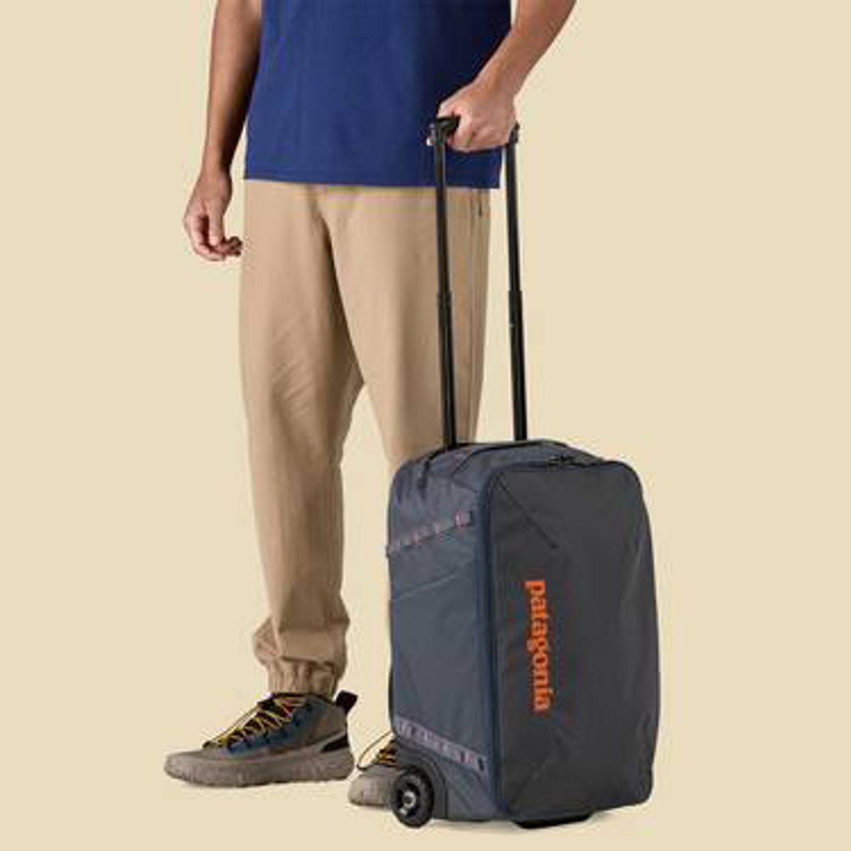 A person stands next to the Black Hole MLC Wheelie 34L.
