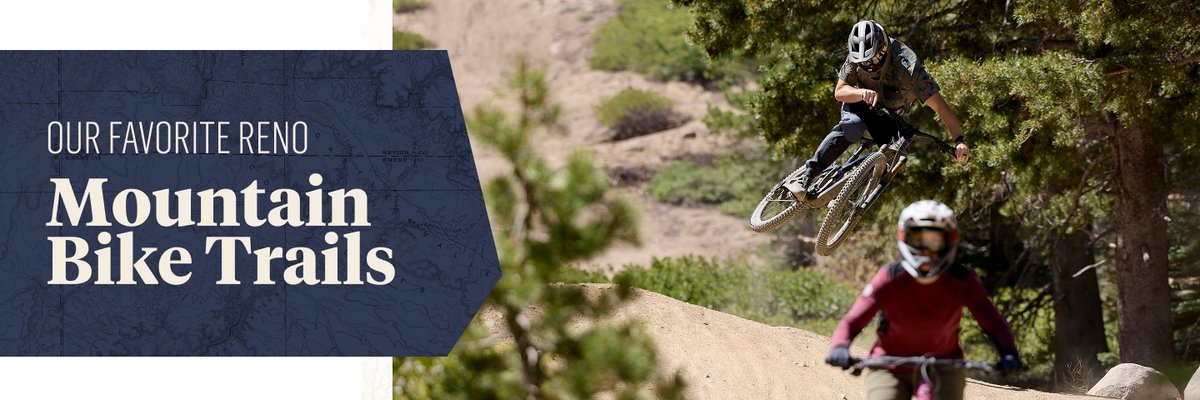A banner image features the text "OUR FAVORITE RENO Mountain Bike Trails" in large letters on a dark blue panel to the left. On the right, two people are catching some air on a dirt mountain biking trail through a forested area, with one rider airborne above the trail while the other preps for the next jump below.