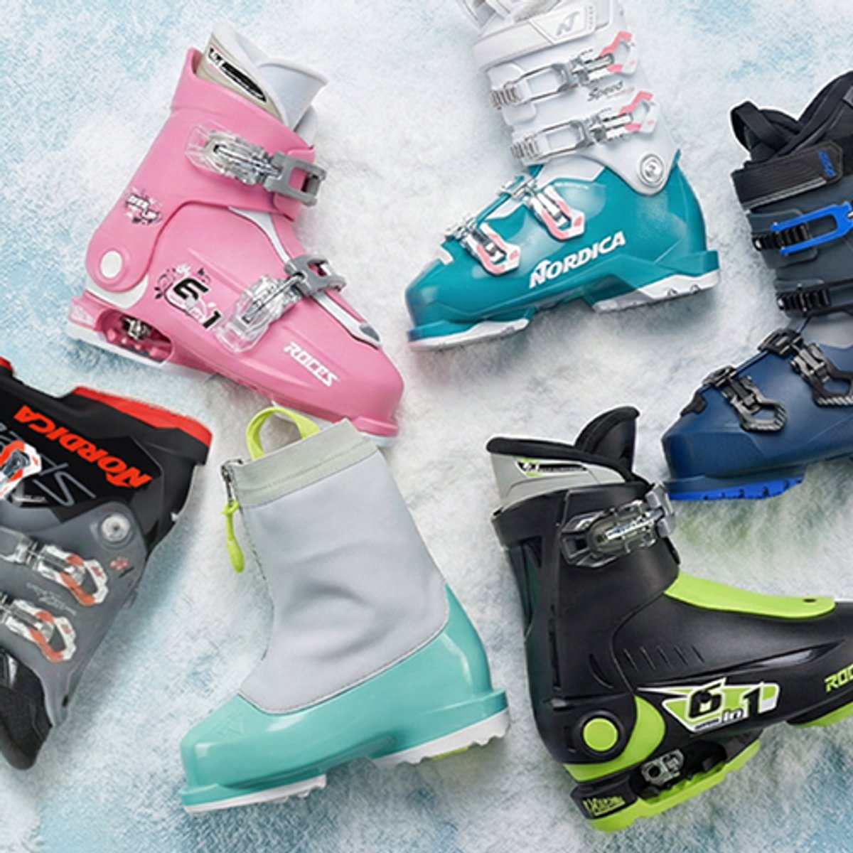 Kids' ski boots and skis staged on a snowy background.