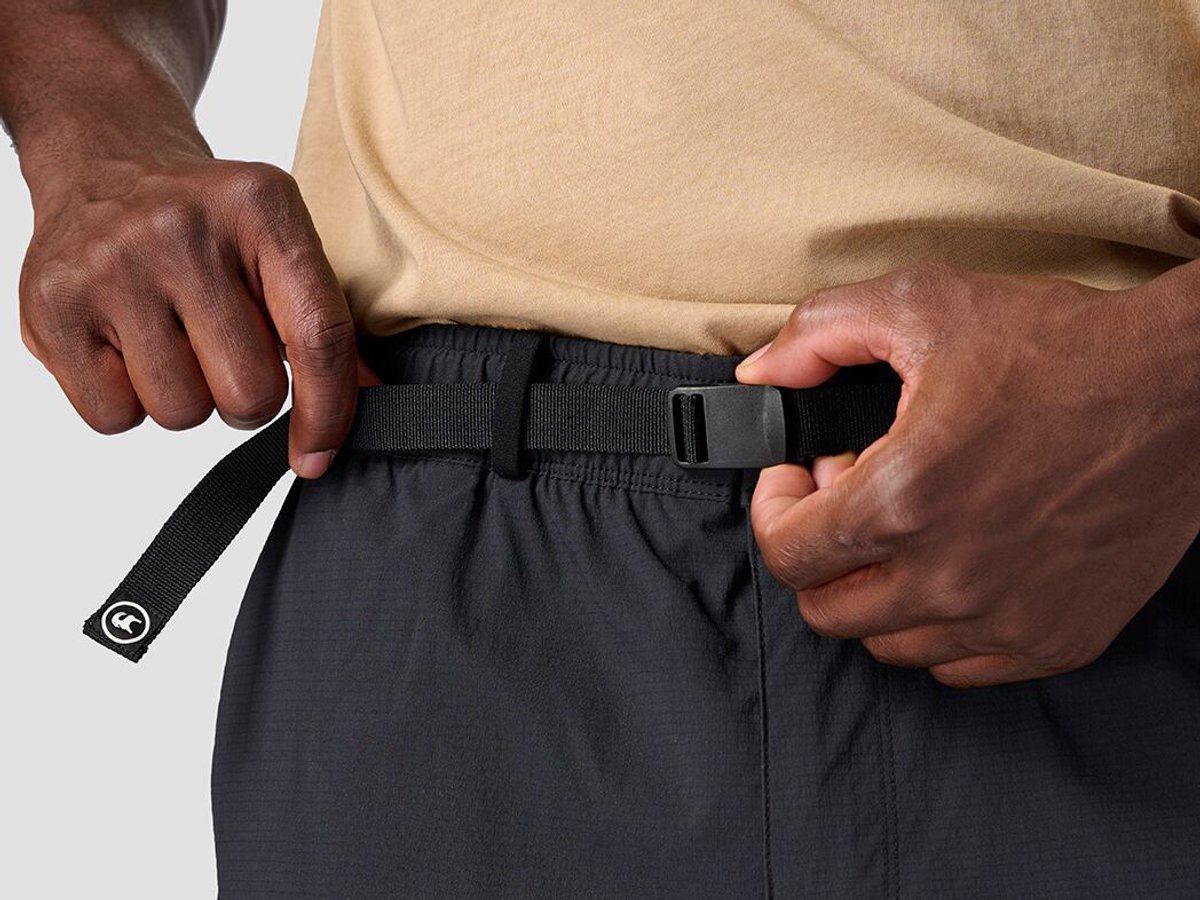 Detail of person cinching integrated belt on ripstp bottoms