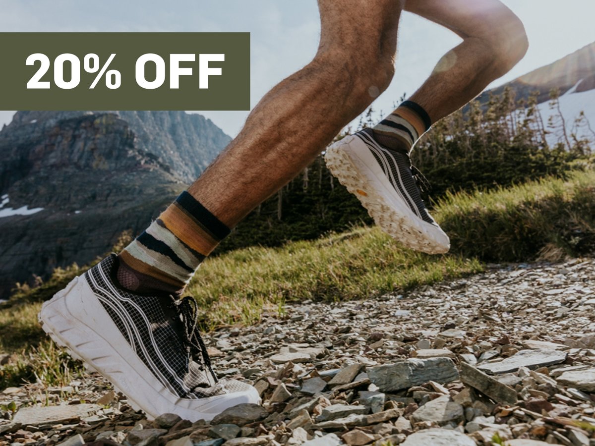 Someone runs up a hill.  A promotional flag says 20% off in the top right corner.