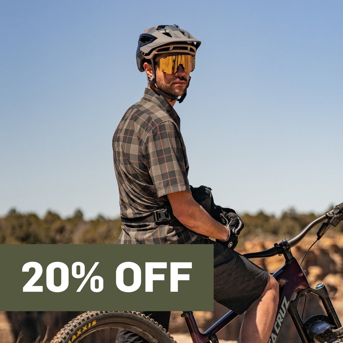 A man on a mountain bike looks over his shoulder.  A promotional flag says 20% off in the top right corner.