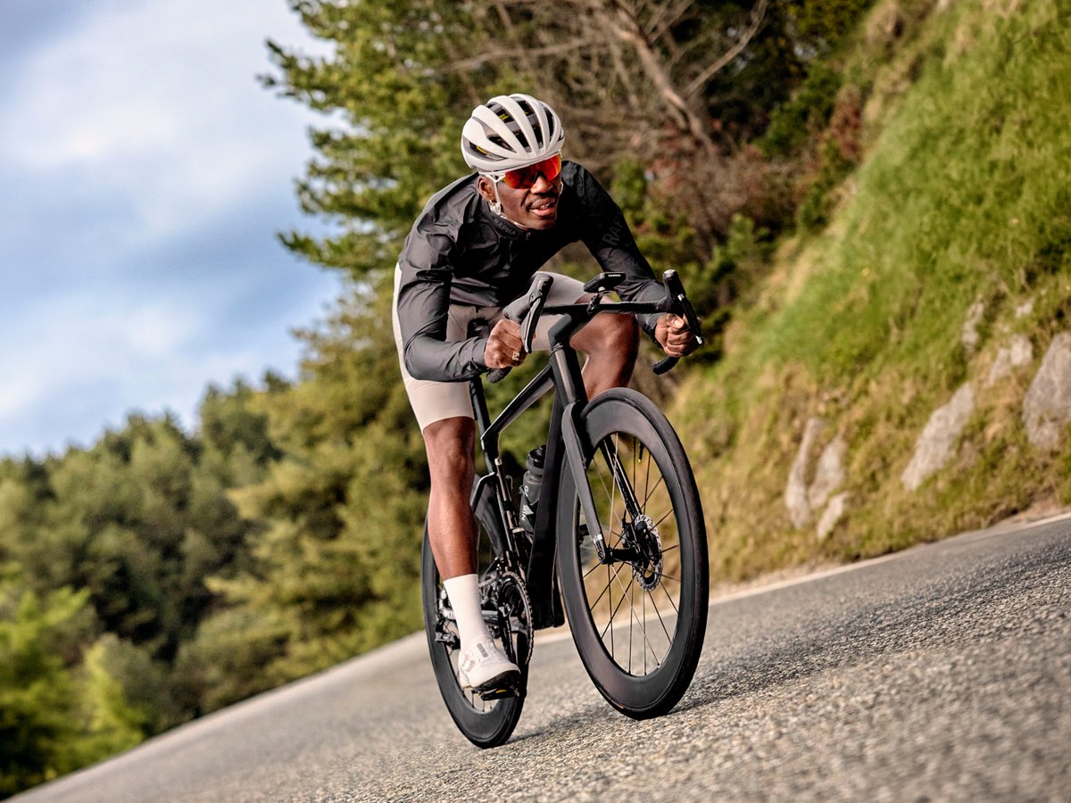 A man bikes along a road, the Garmin Edge 1060 mounted on his handlebars.