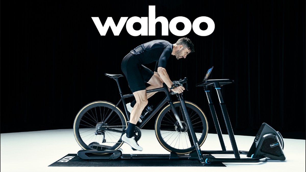 A man on a stationary bike rides in a studio, focused intensely.