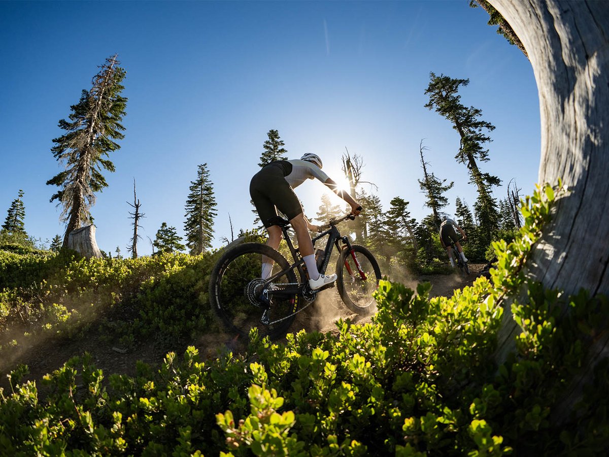 Biker riding pedaling hard up a technical rocky section.