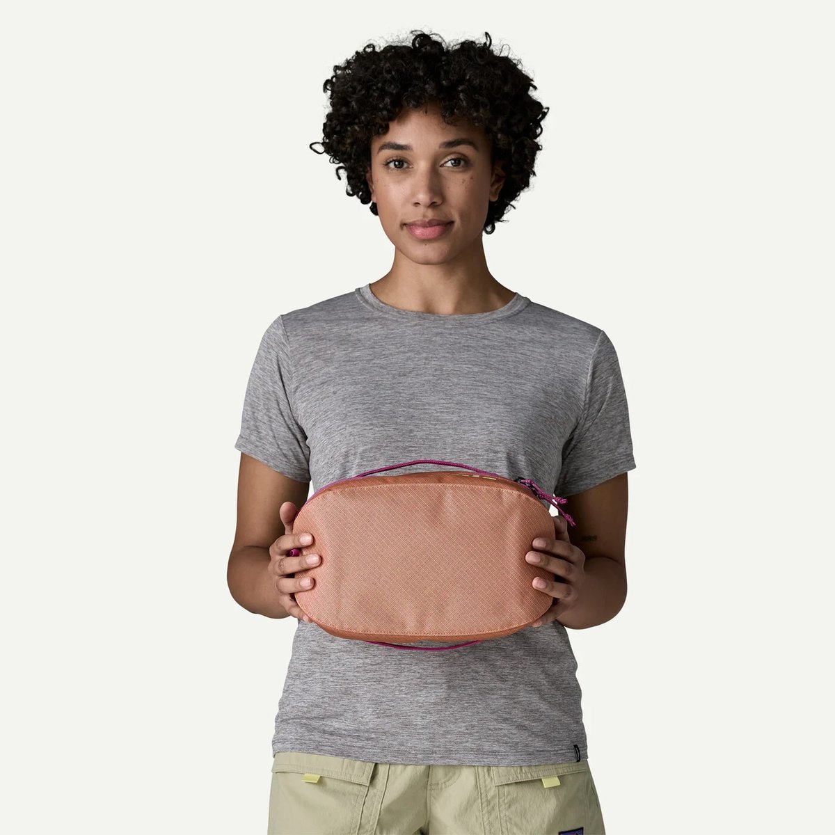 A woman holds a 6L Patagonia Black Hole Packing Cube. 