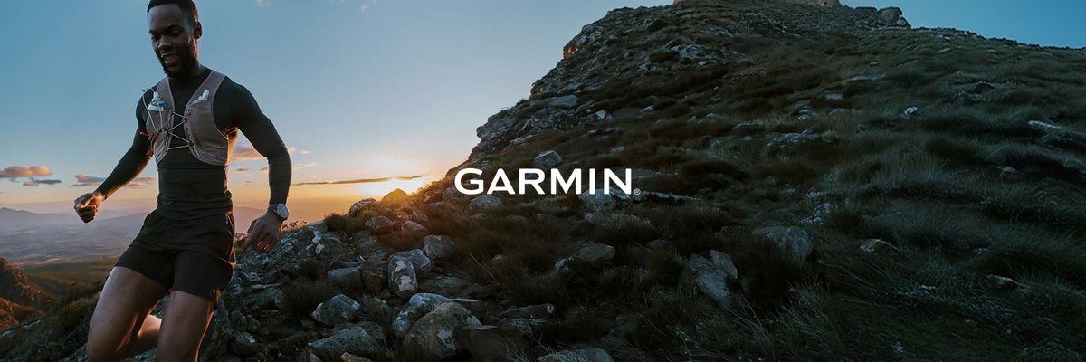Trail runner on a mountain ridge at sunset wearing a running vest, featuring the Garmin logo overlaid.