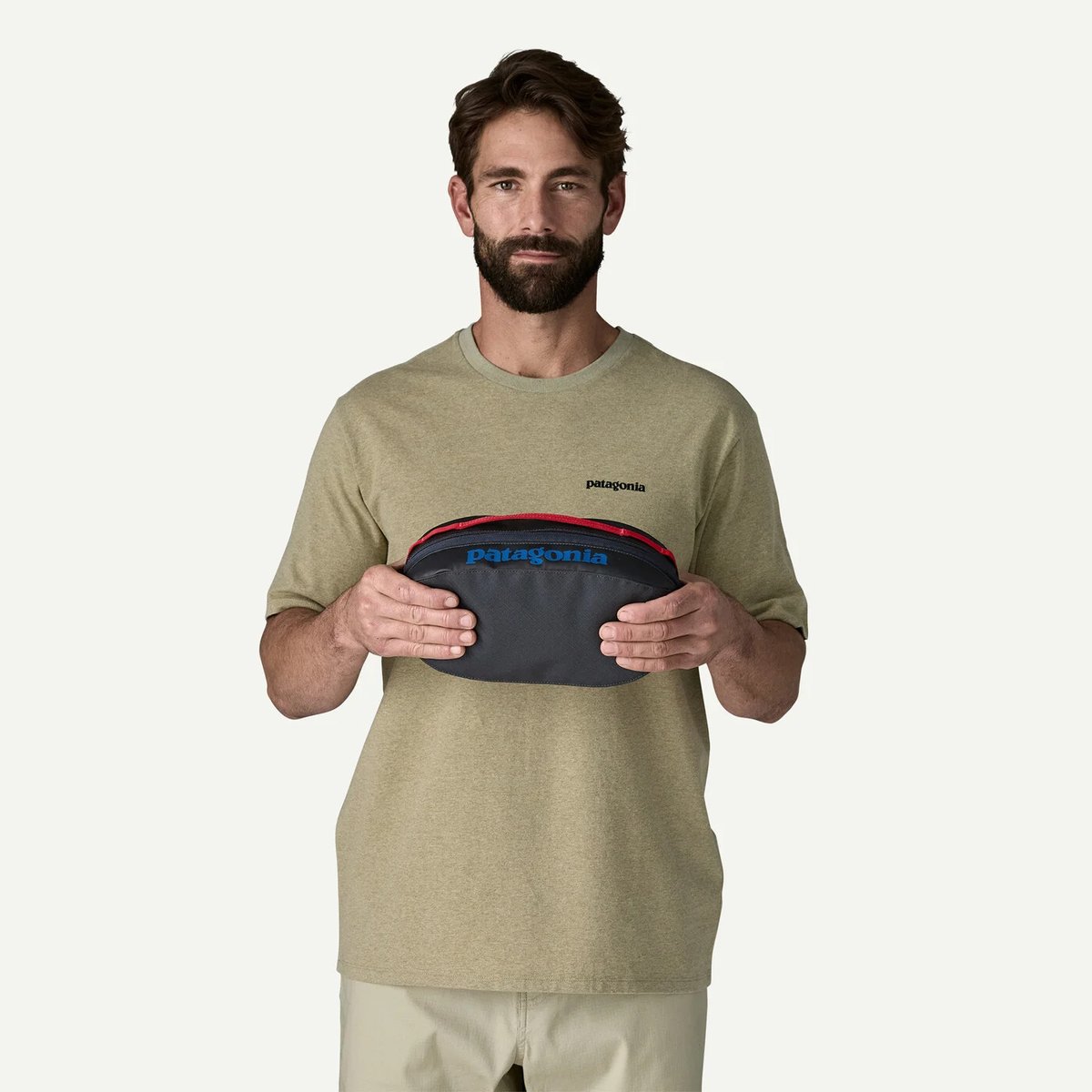 A man holds a Black Hole Packing Cube 3L.