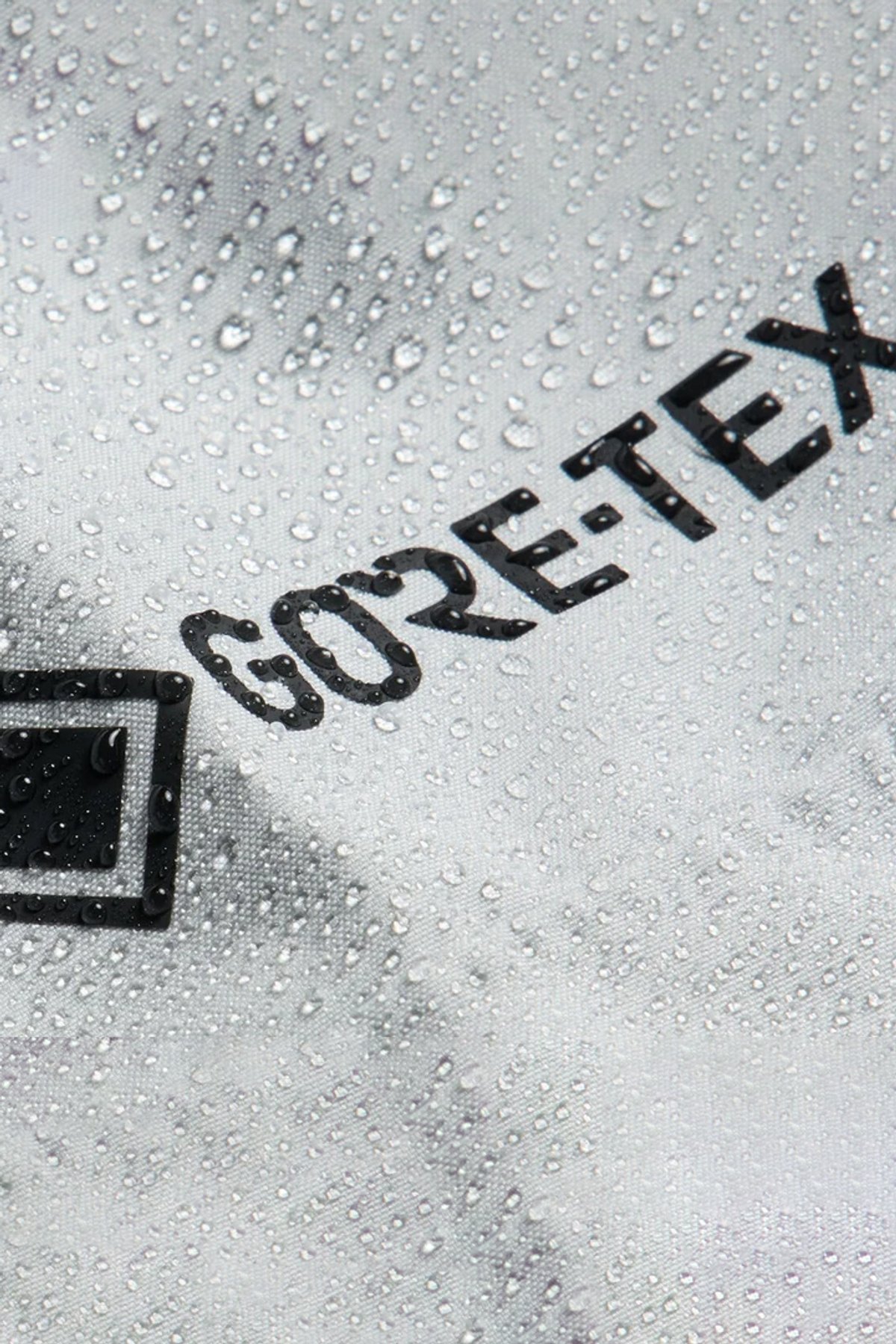 Waterproof Gore-Tex fabric with water droplets beading on the surface, demonstrating moisture-resistant performance.