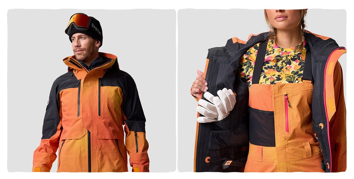 A man and a woman wearing ombre orange snow jackets and bib pants.