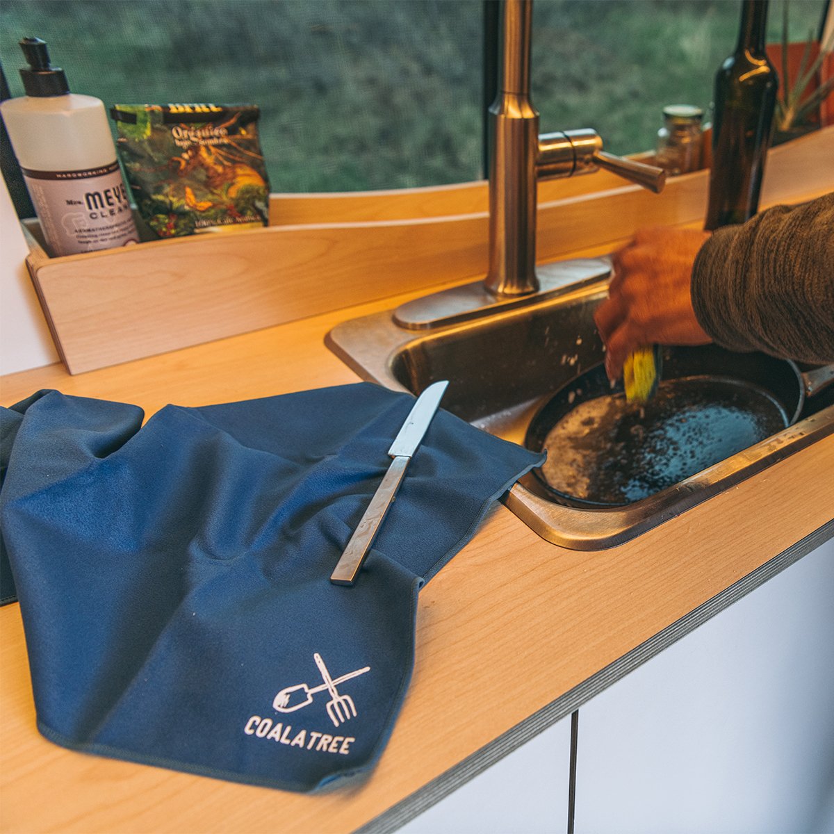 Camper kitchen counter with Coalatree Microfiber Towel layed out as drying surface for washed dishes.