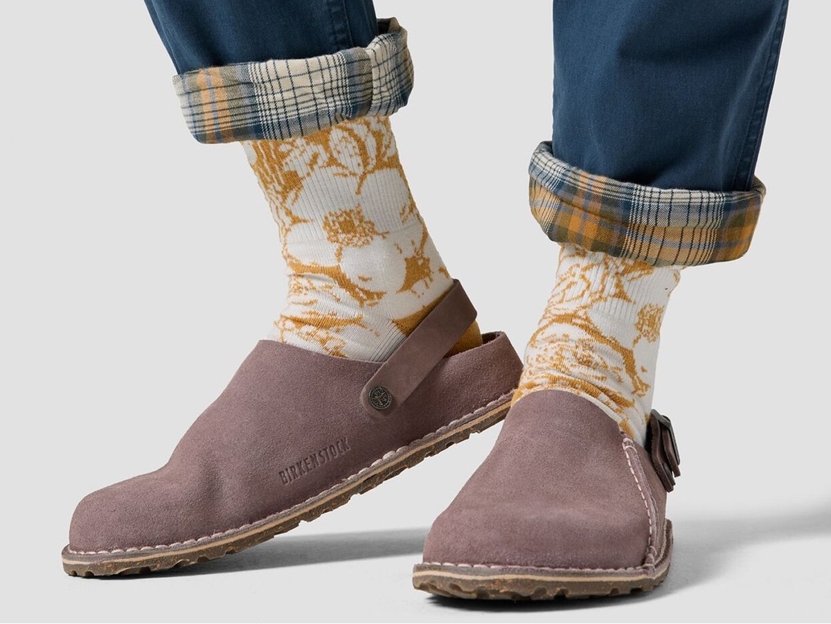 Close-up of flannel-lined cuffed green pants on someone wearing socks and clogs.