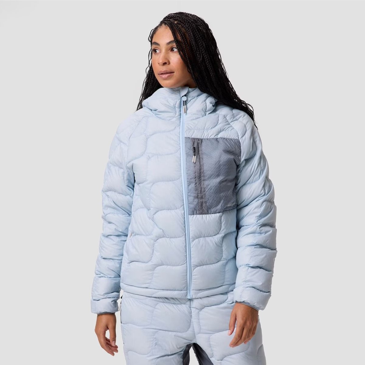 A woman wears the BGA Waas ALLIED Down hooded jacket.