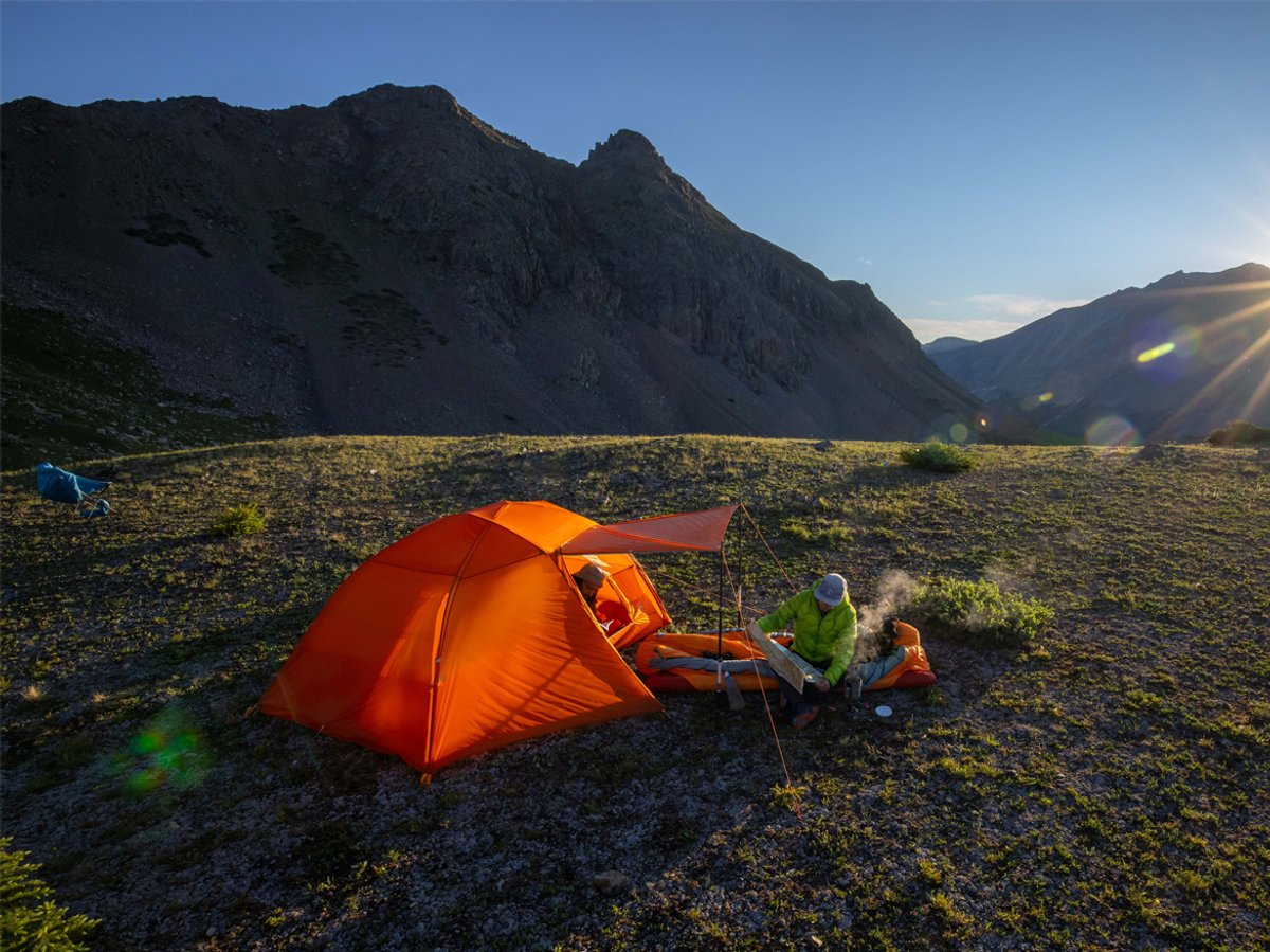 A person camps in the backcountry in their Copper Spur tent