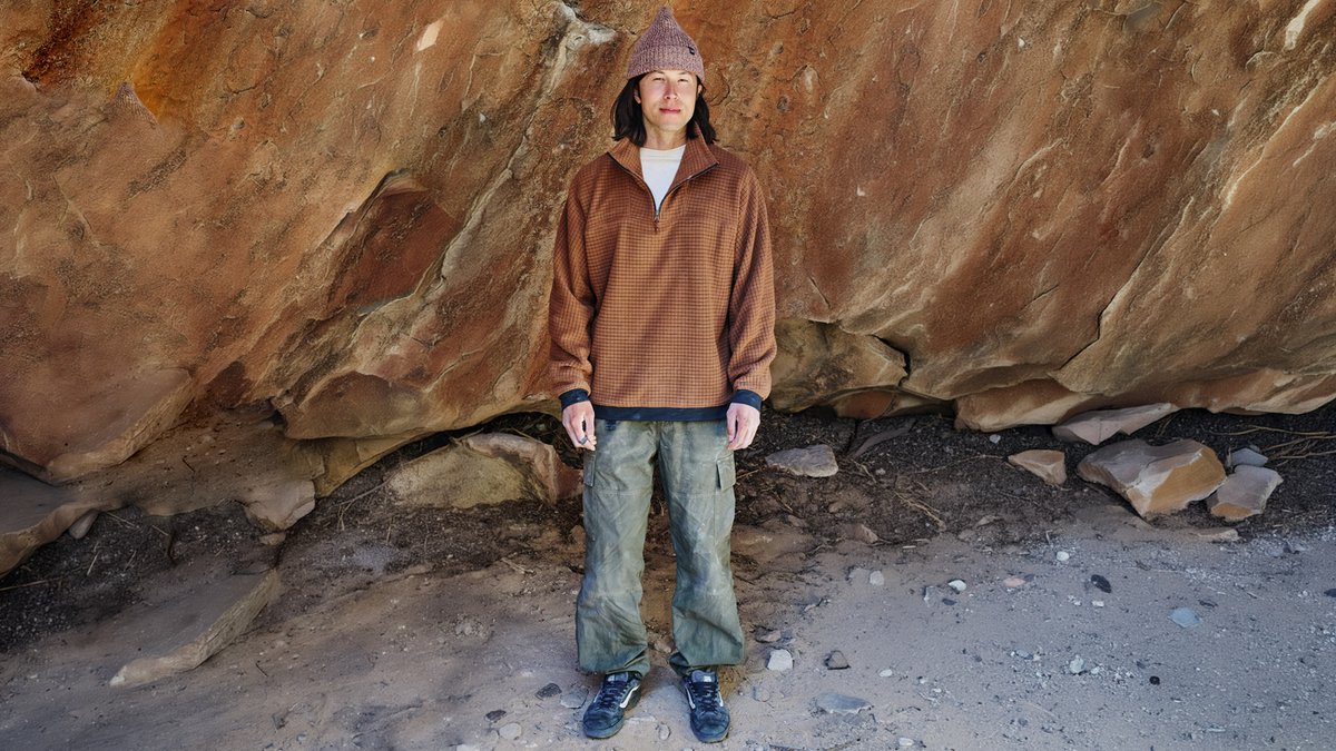 A man wears a Mountain Hardwear Grid Fleece, silhouetted against red rocks.