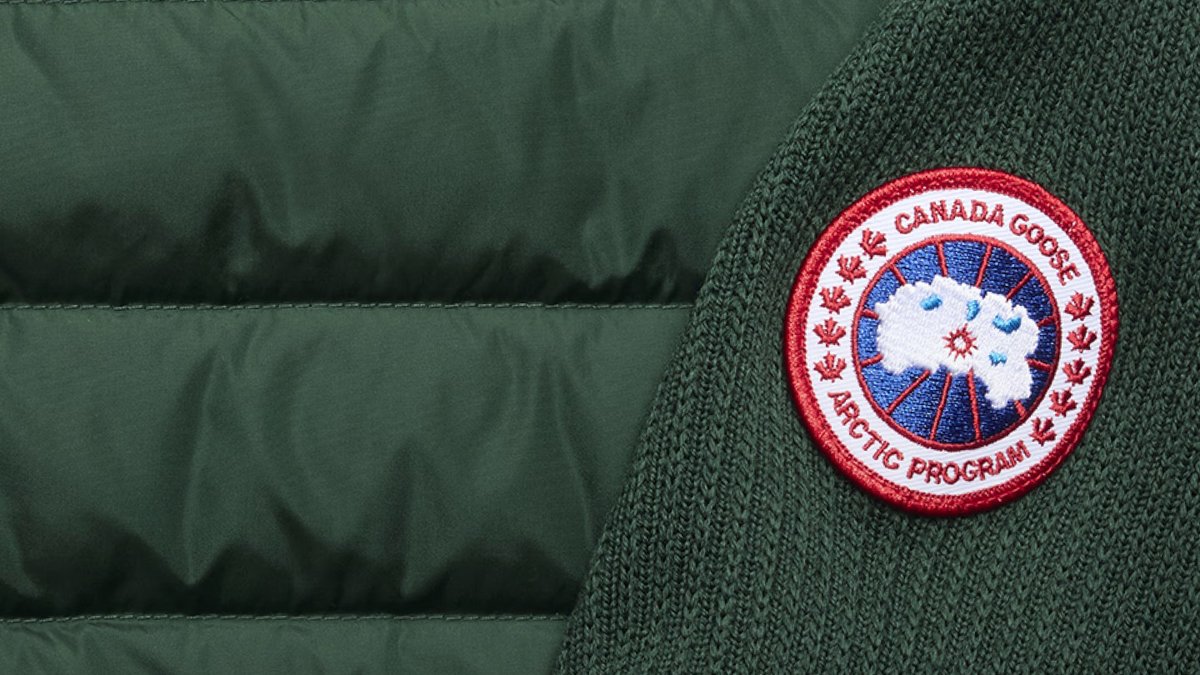 Canada Goose Arctic Program red circular patch badge on green fabric of winter parka jacket.