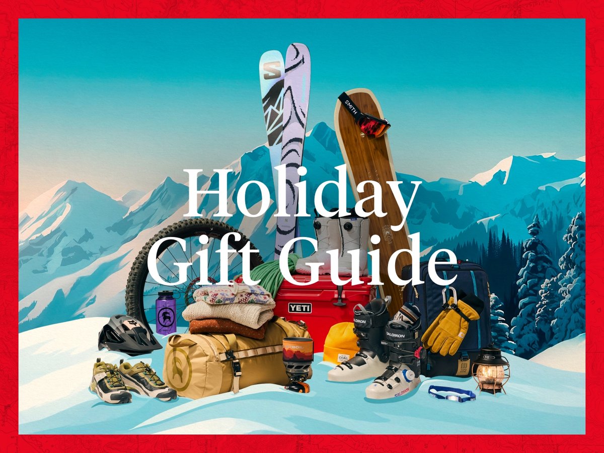 Outdoor gear and apparel piled on a snowy mountain. Text reads Holiday Gift Guide