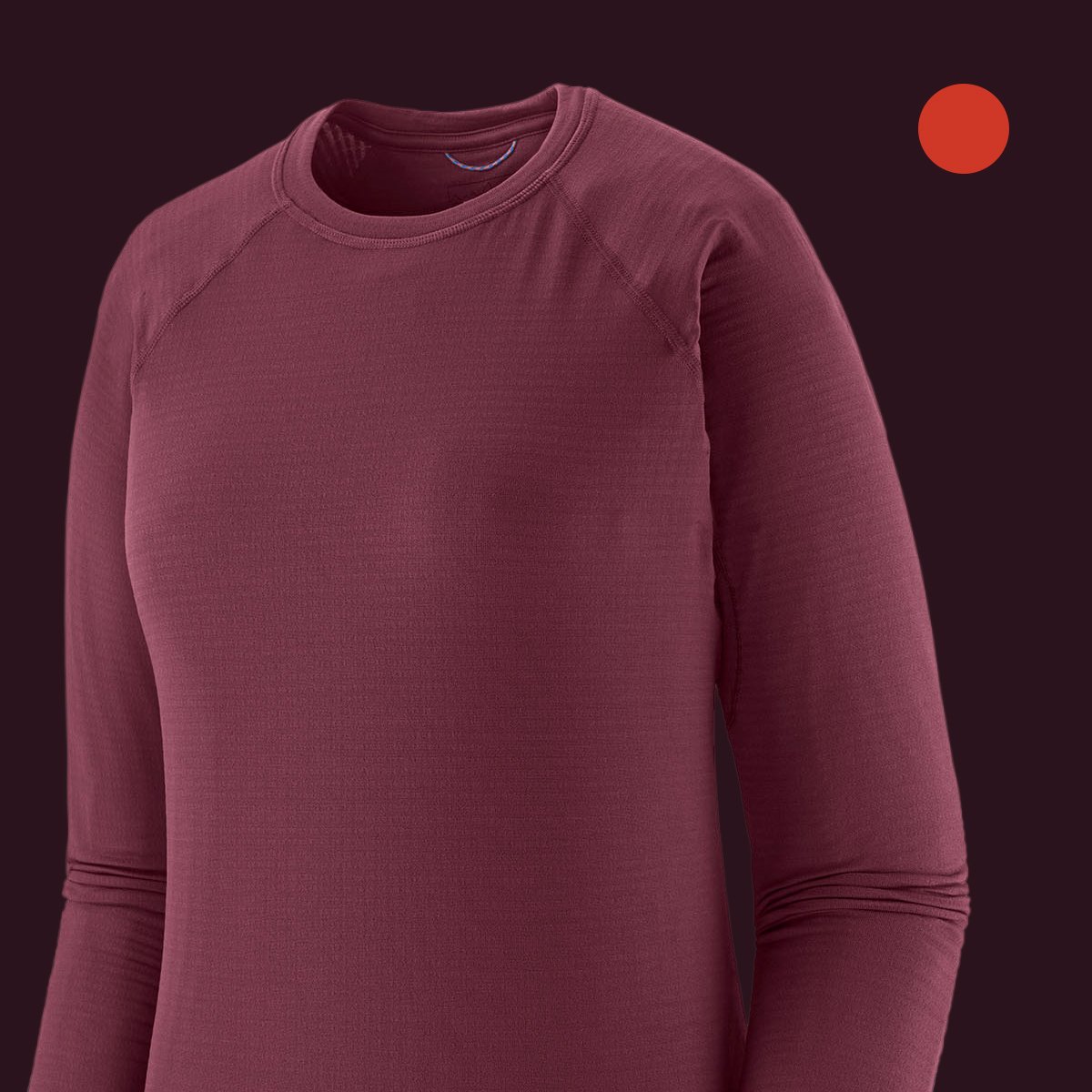 Close-up of a solid maroon long-sleeve crew-neck baselayer top with a subtle ribbed texture, showing the collar and shoulder seam, on a dark maroon background with a red-orange swatch.
