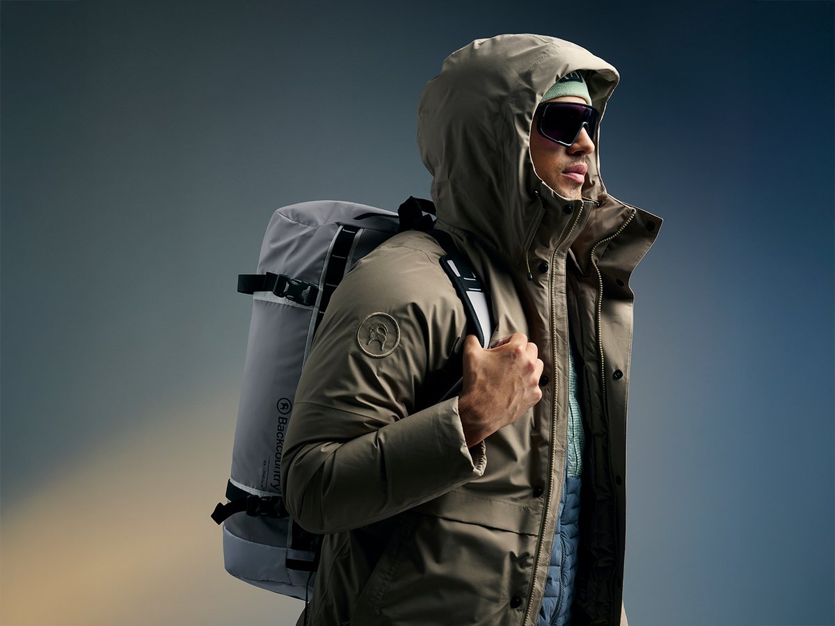 Model wearing jacket and carrying a backpack.