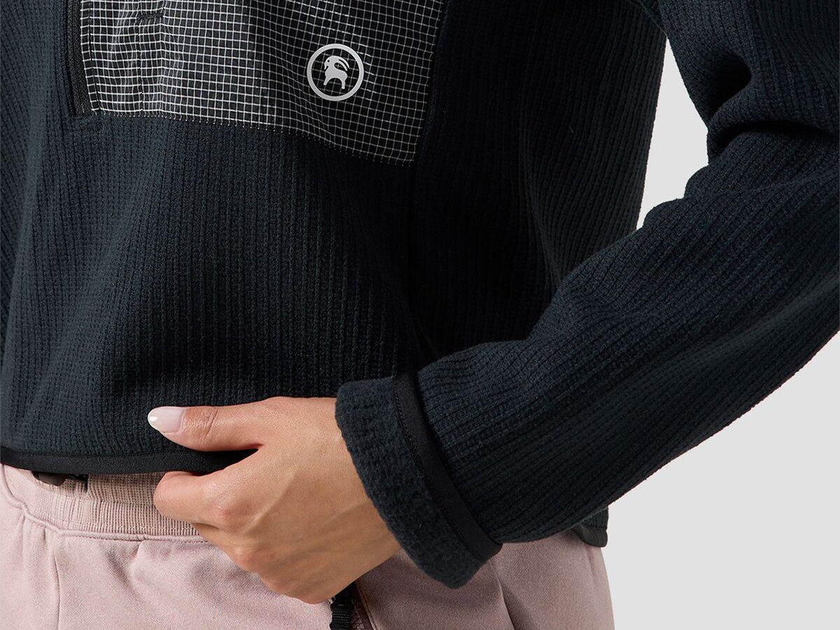 Model holding sweater hem.