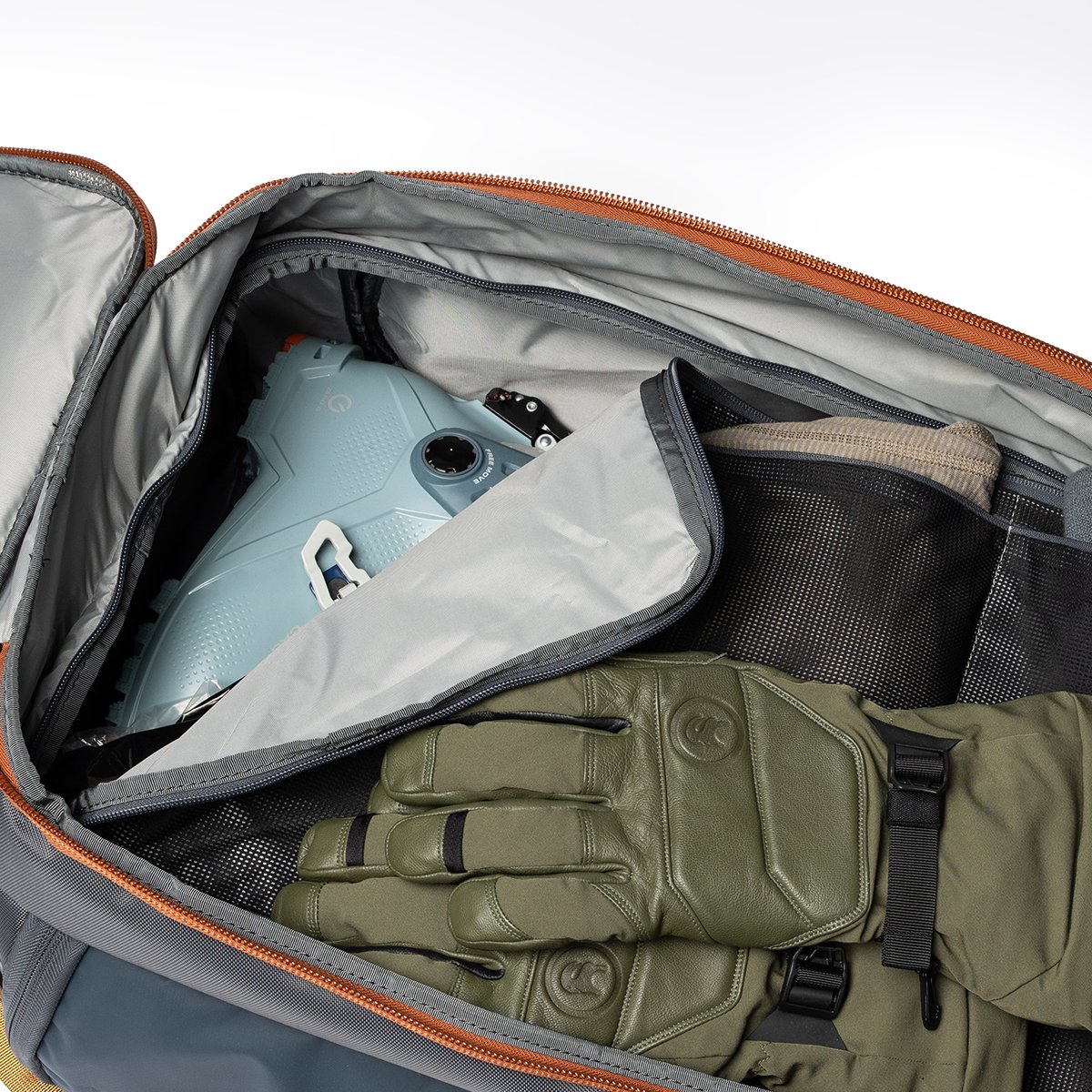Boot bag’s divider packed with ski boots underneath and gloves and layers in the upper compartment.