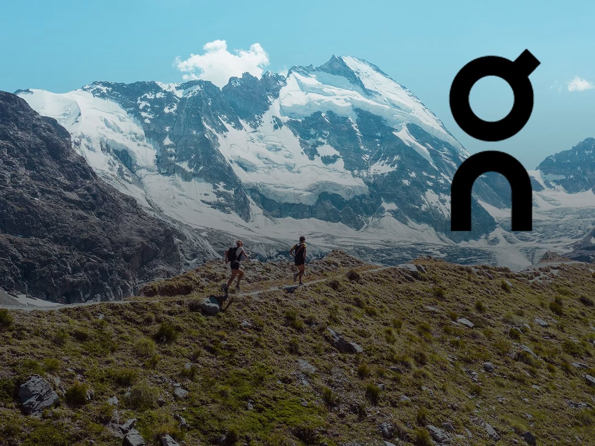 Two trail runners on a mountain trail with snowy pea in teh background and an "ON" logo overlay.
