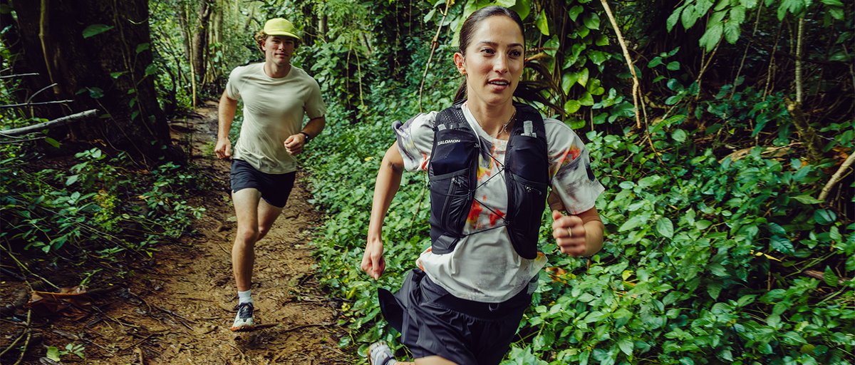 Two runners springing along jungle trail.