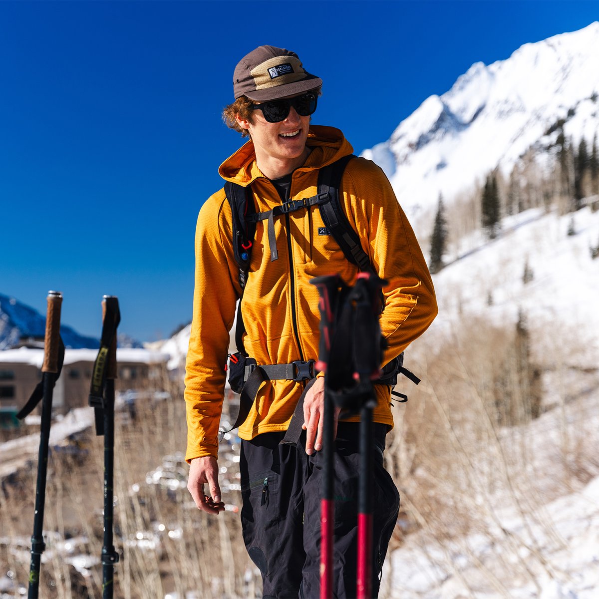 Backcountry skiier wearing Coalatree workwear hat standing with snowy mountains in the background