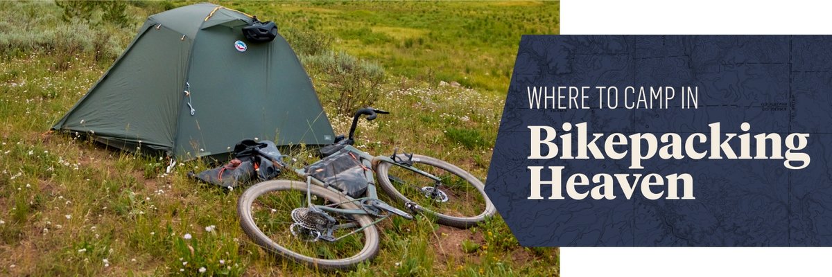 Bikepacking gear on a grassy knoll. Text overlay reads: Where to camp in bikepacking heaven