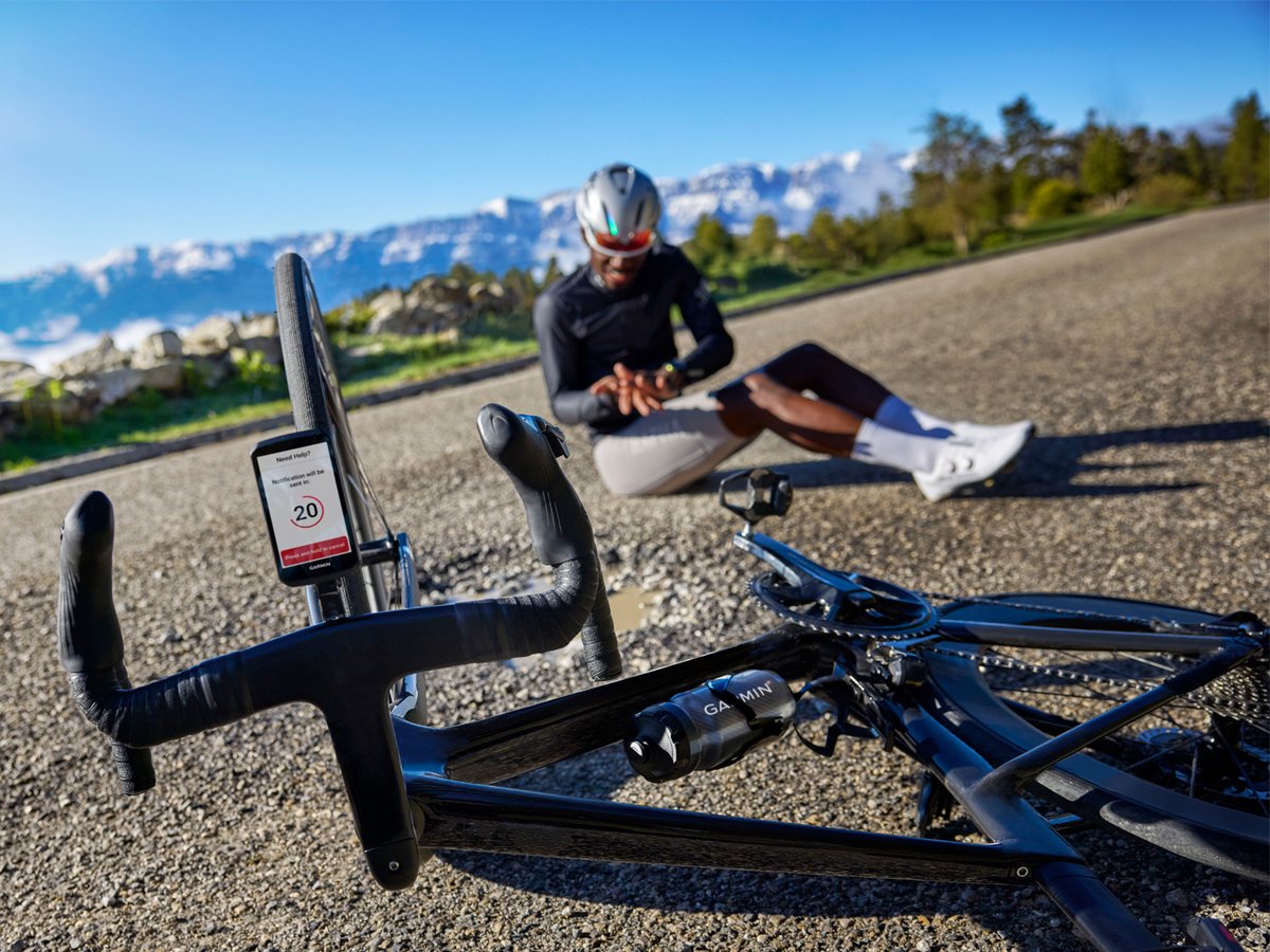A biker has hit a pothole and fallen off their bike. The Garmin 1060 showcases its crash feature, set to send a message for help in 20 seconds.