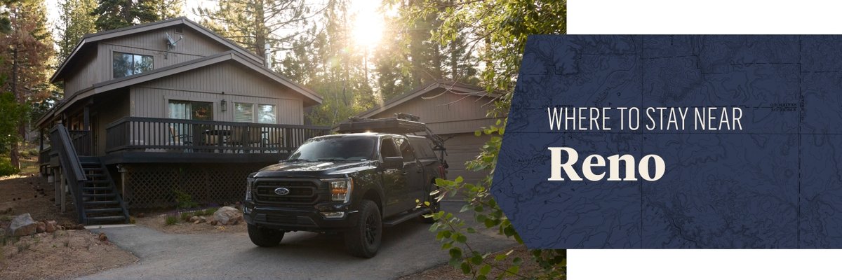 A black pickup truck is parked in front of a two-story house with a wraparound porch and steps, surrounded by tall trees and sunlight filtering through the branches. To the right, a dark blue banner reads "WHERE TO STAY NEAR Reno."