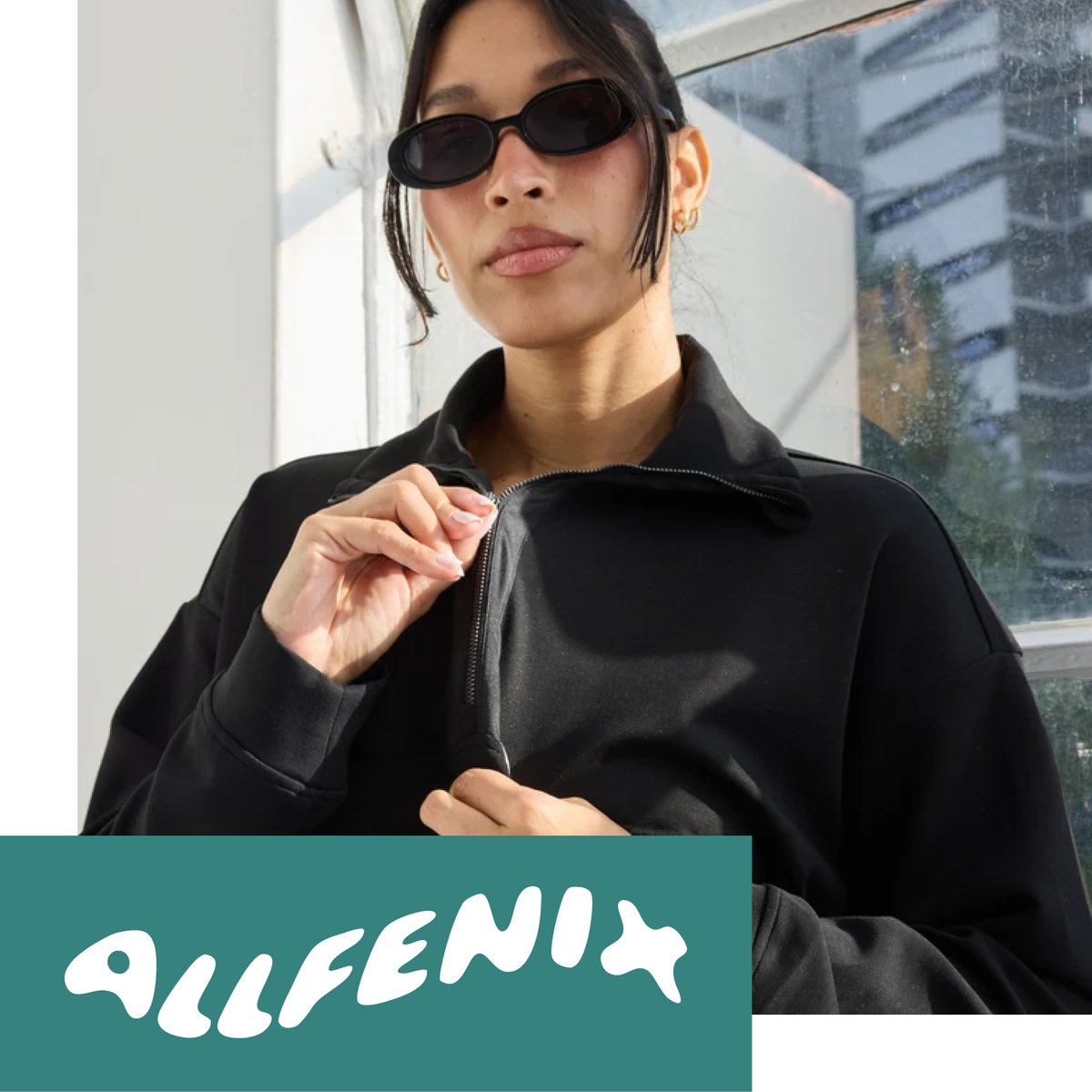 Shop ALLFENIX — woman in oval sunglasses and black zip jacket against urban brick backdrop. Modern minimalist style.