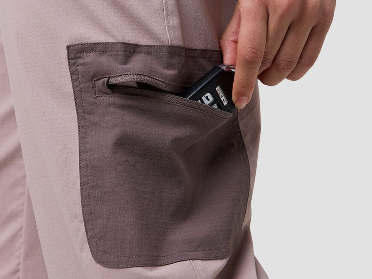 Detail of person extracting car keys from zippered thigh pocket on ripstop pants.