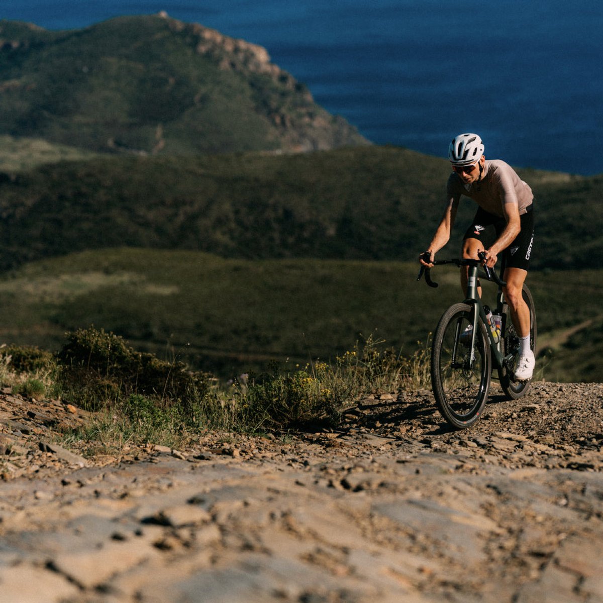 Rider climbing coastal terrain on the ENVE MOG carbon gravel bike