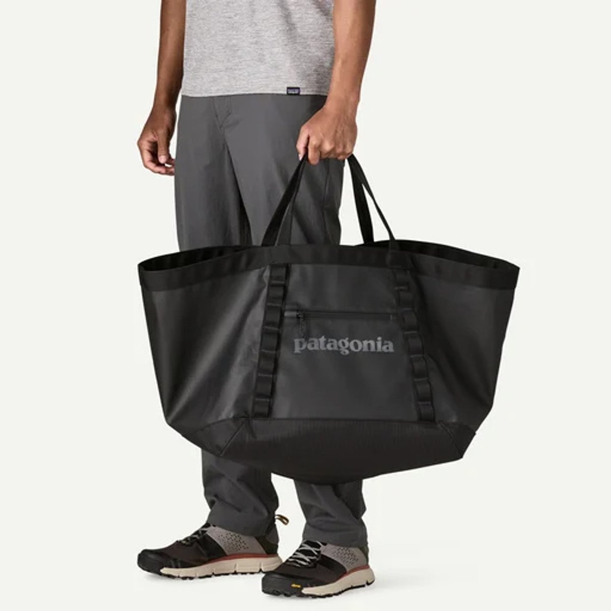 A person holds a Black Hole Gear Tote 61L.