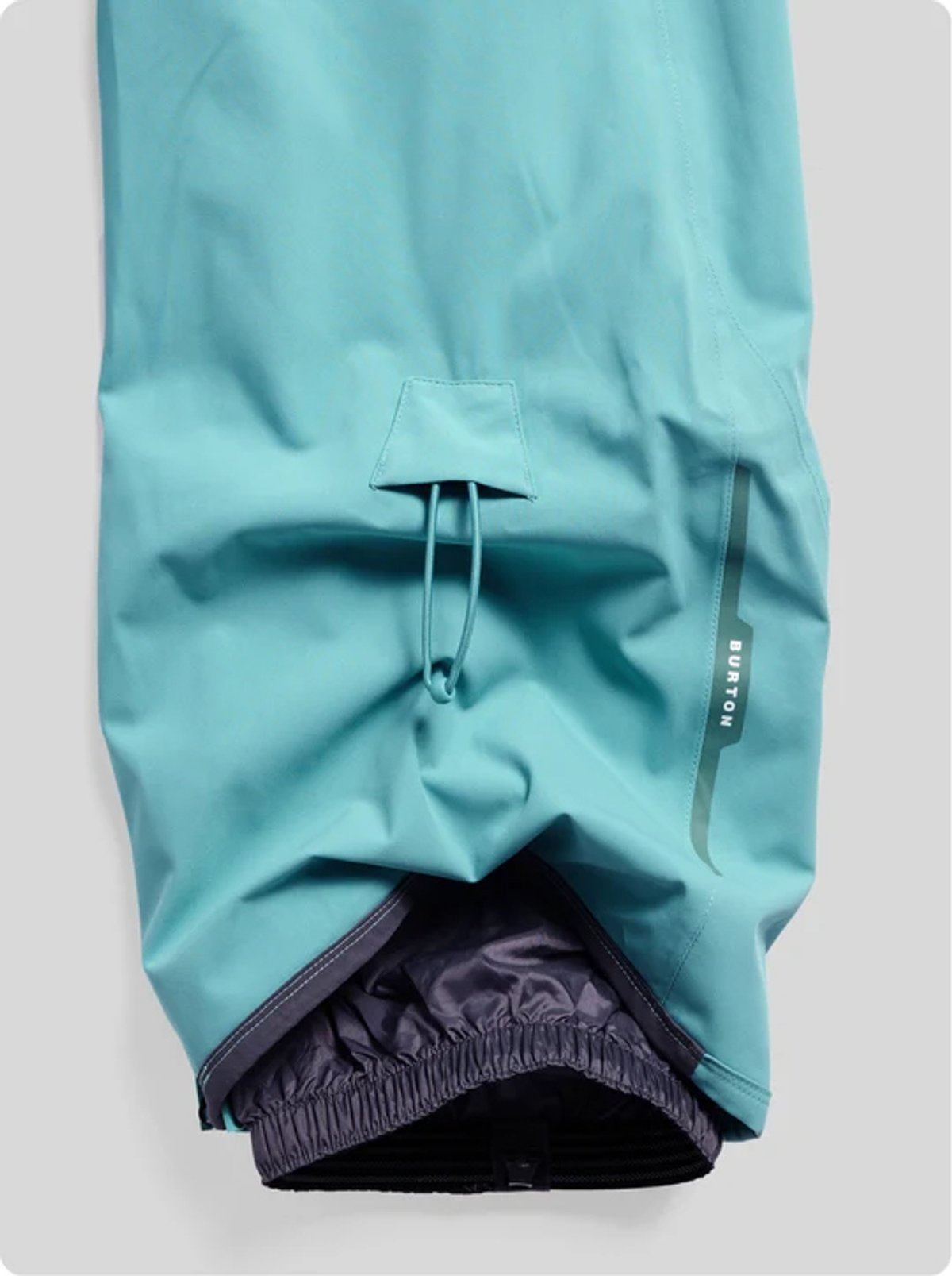 Turquoise blue water-resistant jacket sleeve with drawstring adjustment and black elastic cuff detail displayed on gray background.