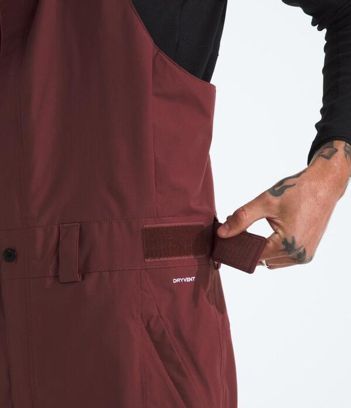Person adjusting hook-and-loop waist tabs.