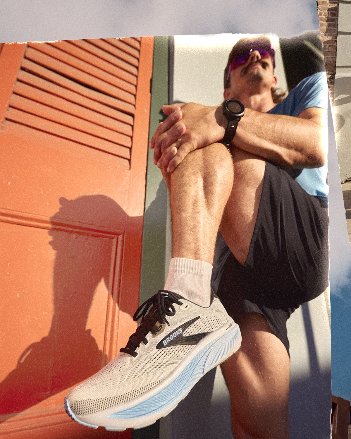 Person stretching out their leg against a wall wearing Brooks Ghost 18 runnning shoe
