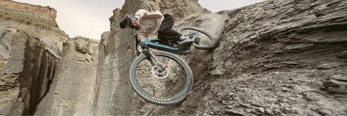 A downhill rider speeding down a steep, gravely trail on a Santa Cruz eMTB.