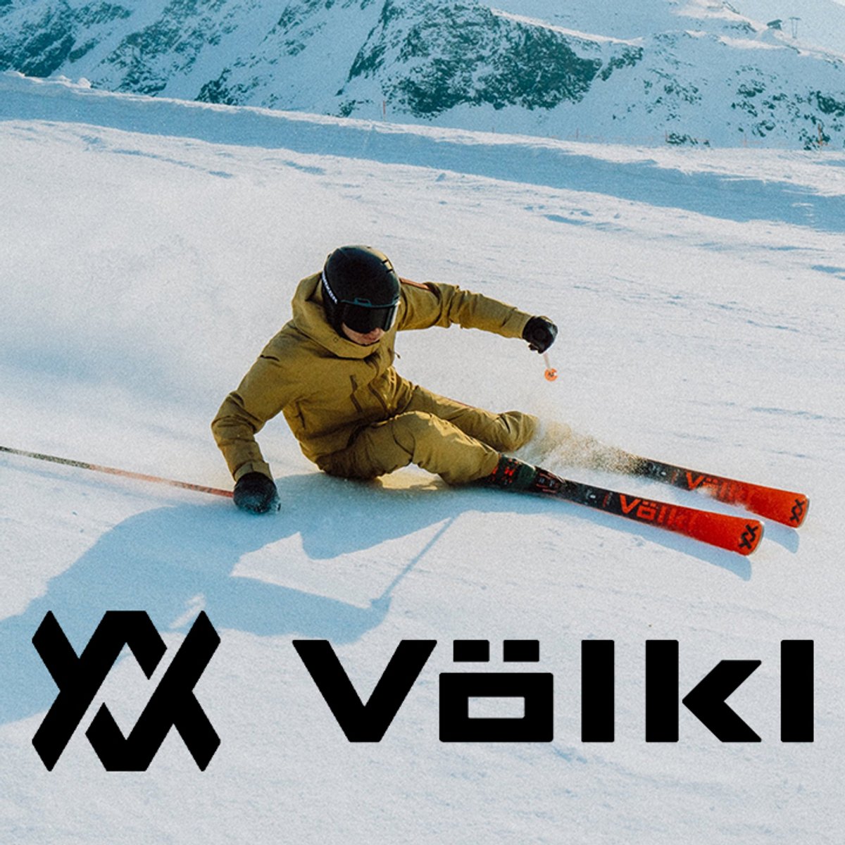 Alpine skier turning on snowy slope using Völkl skis with Völkl logo