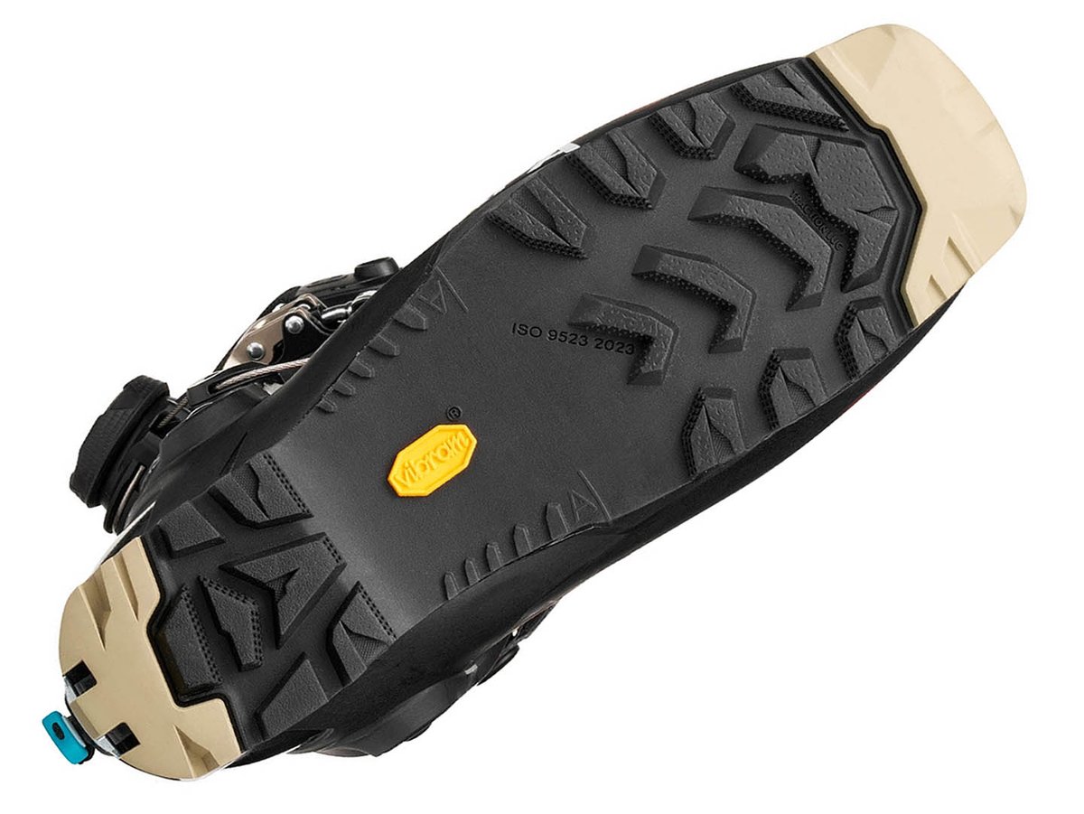 Angled bottom view of SCARPA F1 RS Vibram FS outsole showing Traction Lug tread pattern, yellow Vibram logo, and ISO 9523 binding standard marking