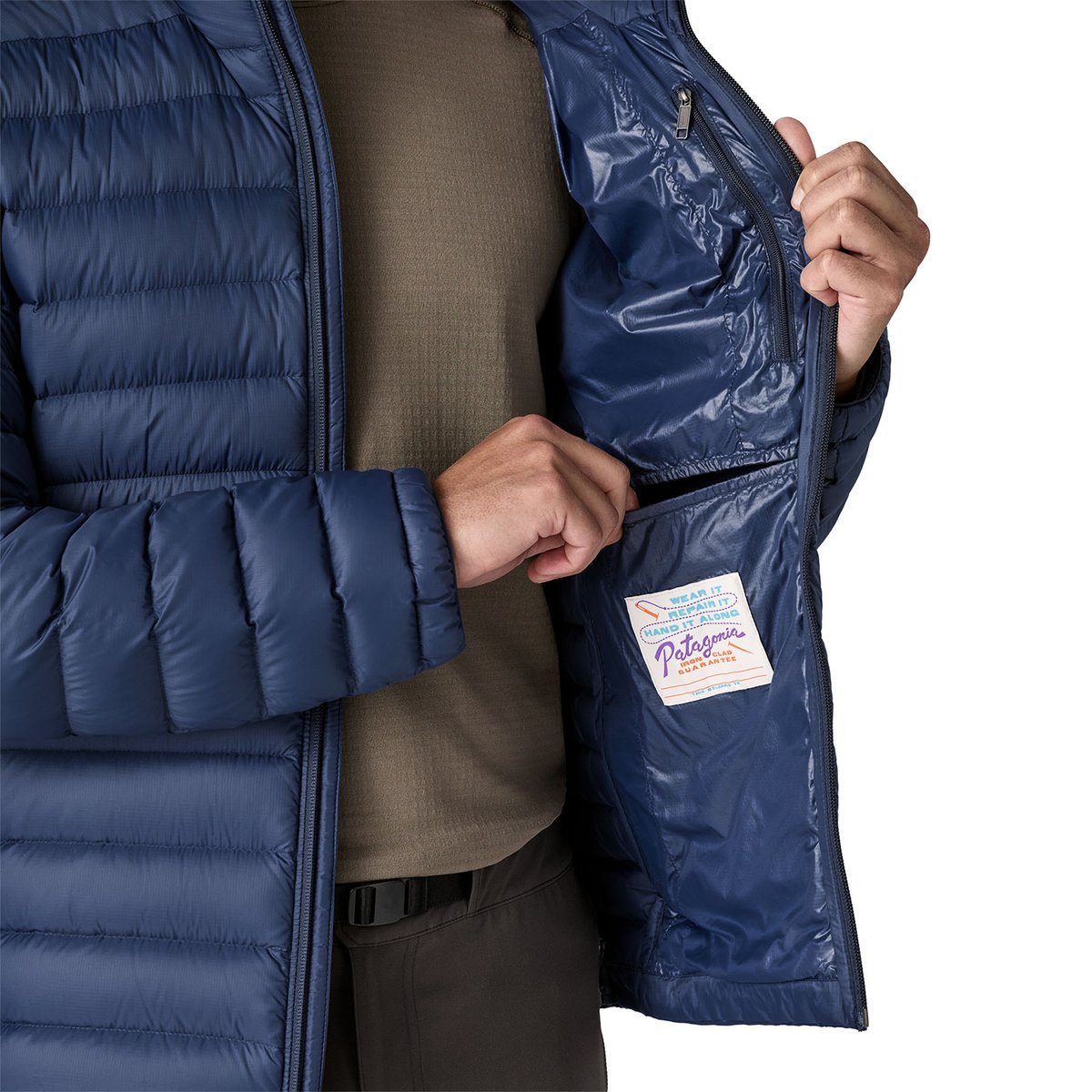A person wearing the Patagonia Down Sweater jacket showcases the interior pockets