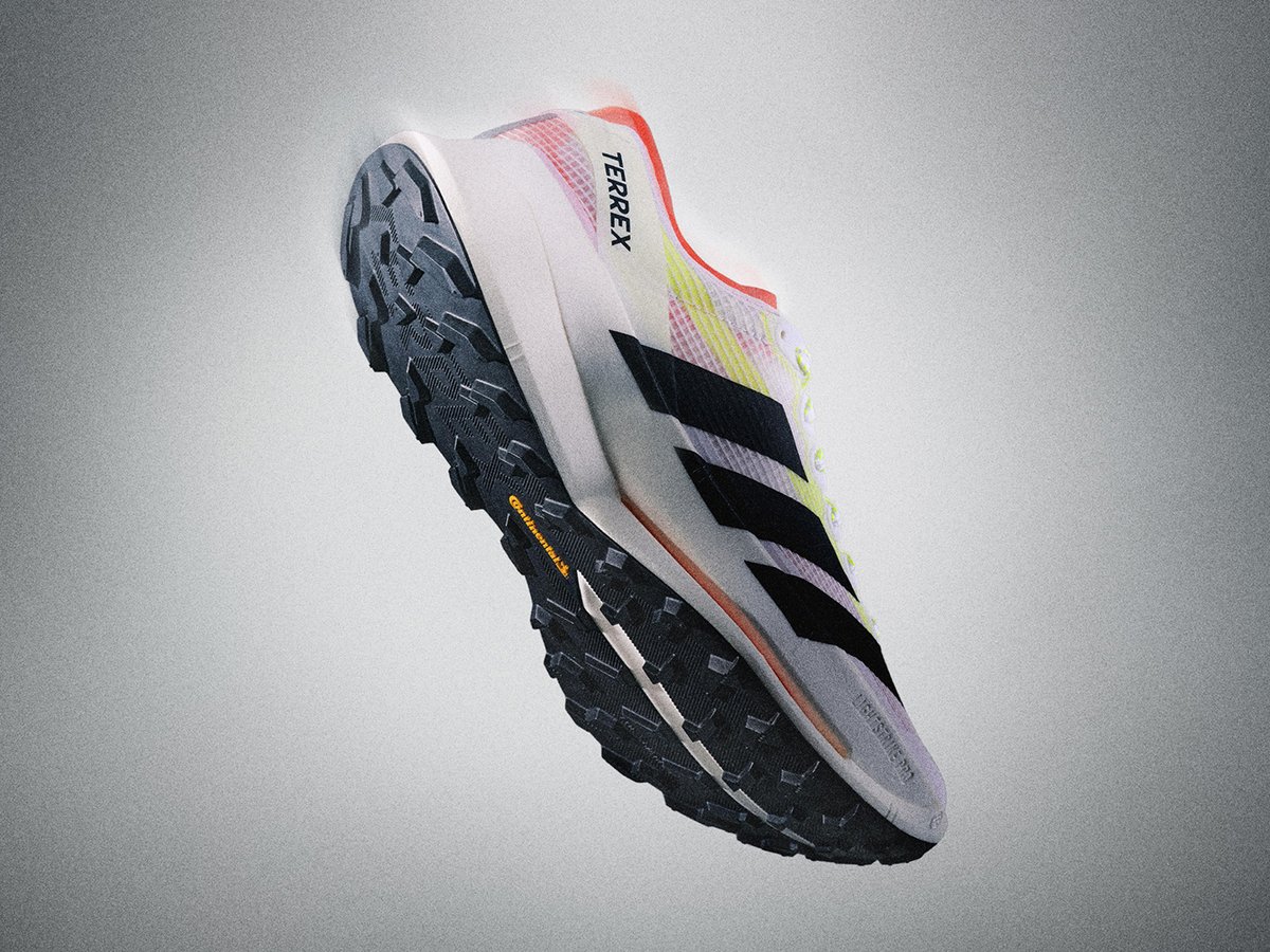 Side shot of trail running shoe showing Adidas logo and lugged outsole. 