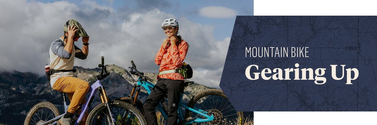 Two people sit on mountain bikes in the mountains. Text overlay reads: Mountain Bike Gearing Up
