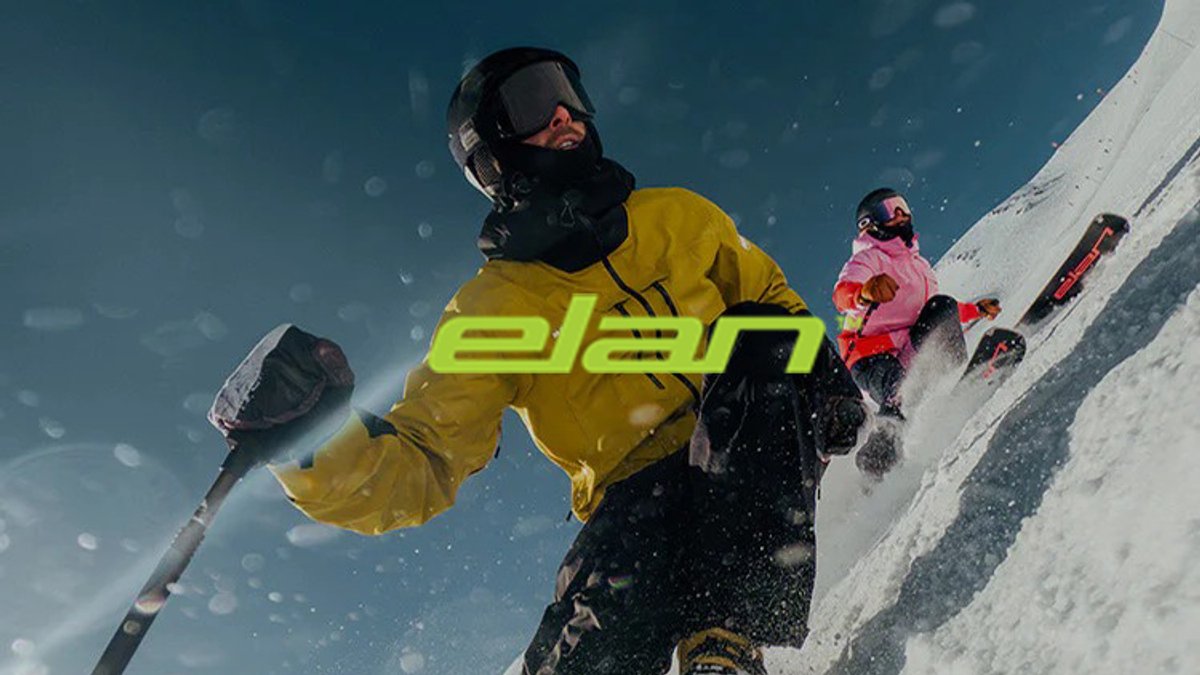 Professional skier in bright yellow jacket descending snowy mountain slope with ski poles and equipment in sunny alpine conditions.