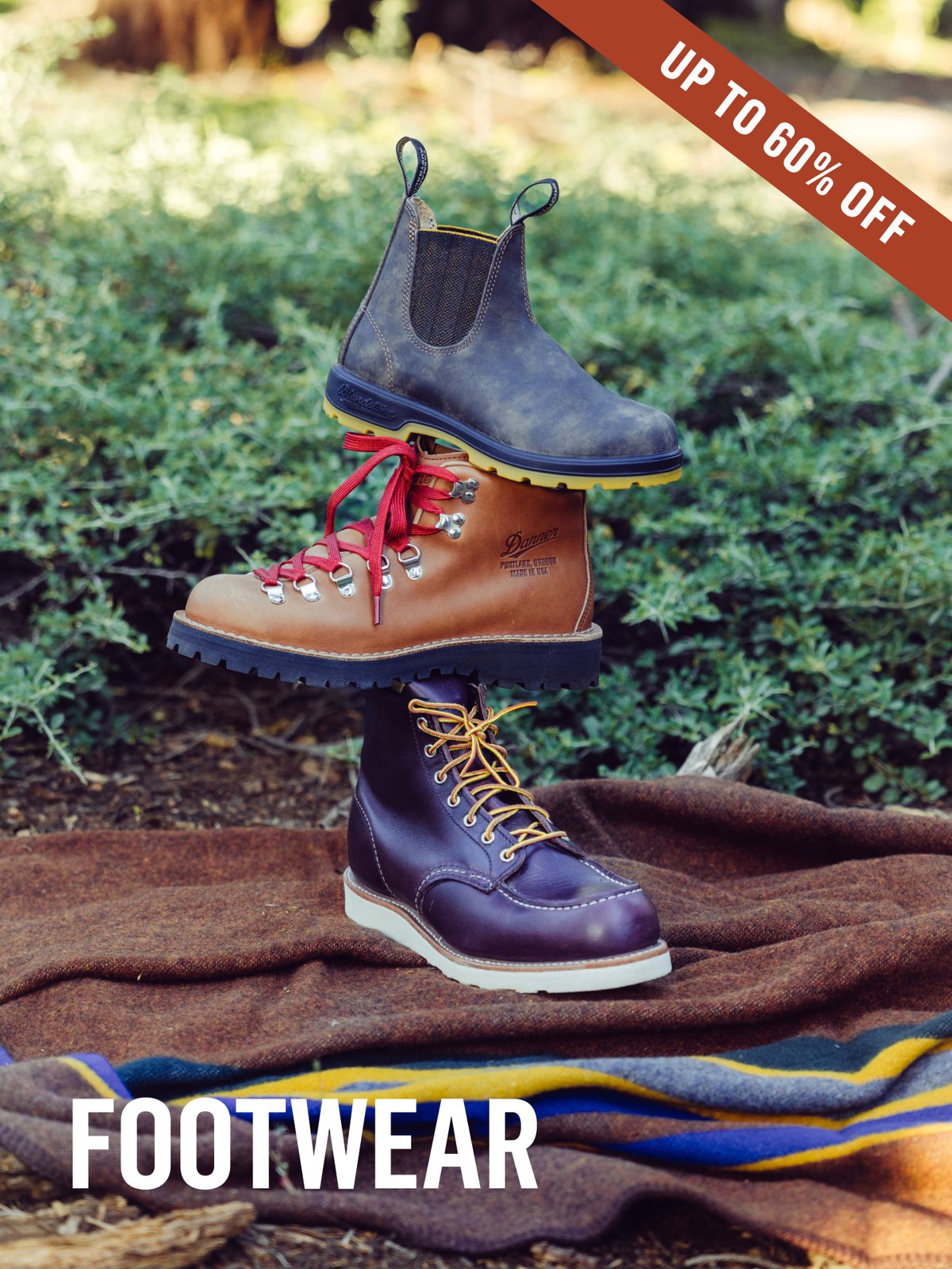 Three boots stacked outdoors on a wool blanket: a Blundstone Chelsea, Danner hiker with red laces, and dark leather lace-up work boot. Footwear Up to 60% off.