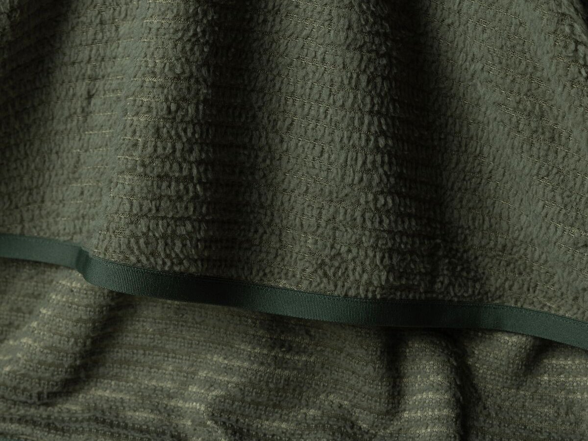 Close-up fabric detail of fuzzy fleece showing external and internal texture.