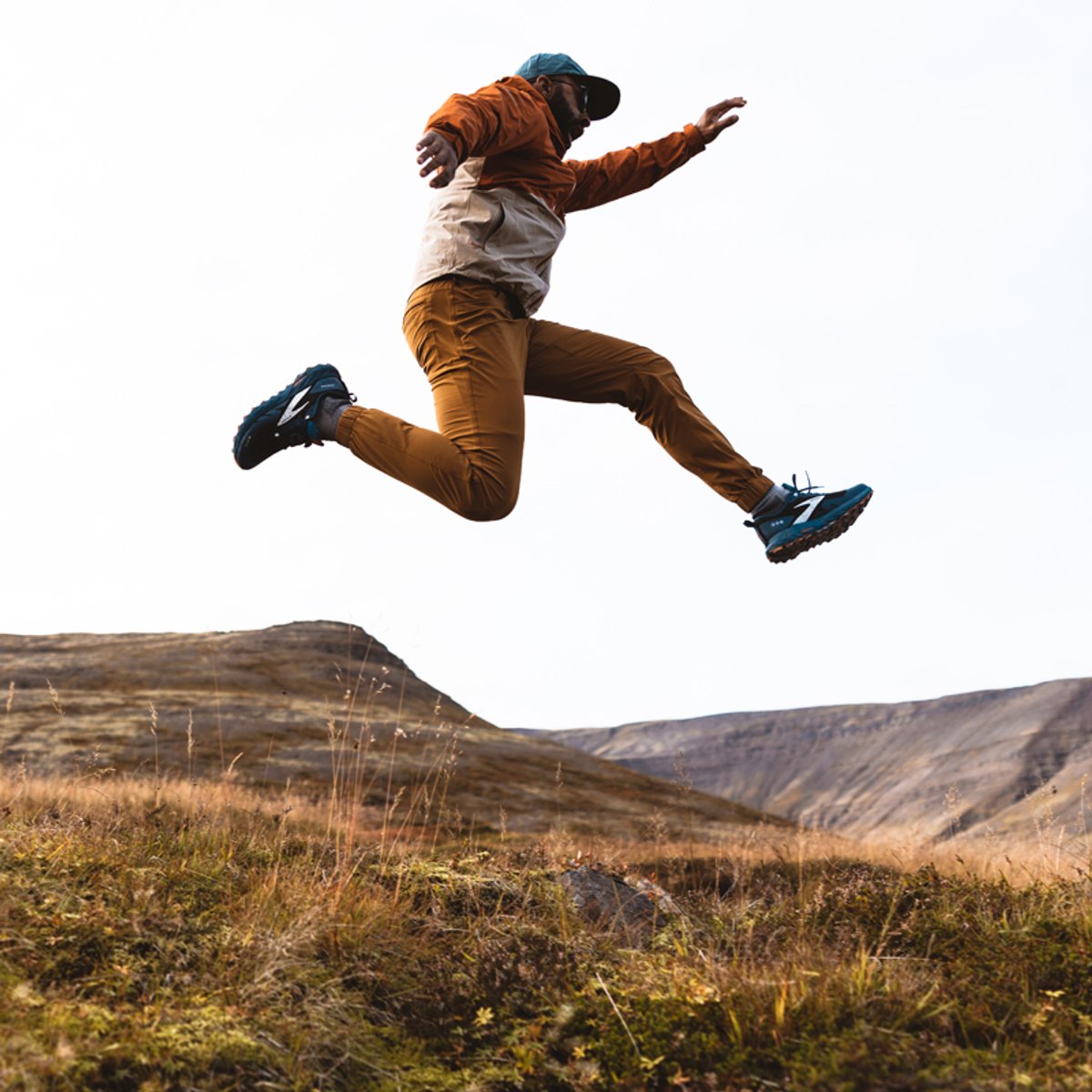 A man wearing Ferrosi pants leaps spectacularly in the air.